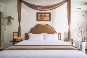 una camera da letto con un grande letto con cuscini bianchi di Poetic Leisure Courtyard Hotel a Yangshuo