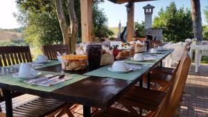 una mesa de madera con platos y utensilios. en La Finestra Sul Cortile en Pomezia