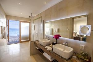 a bathroom with two sinks and a large mirror at Hurawalhi Island Resort in Kuredu