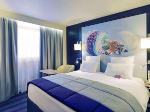 a hotel room with a large bed and a window at Mercure Toulouse Centre Saint-Georges in Toulouse