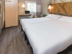Una cama o camas en una habitación de ibis Tilburg
