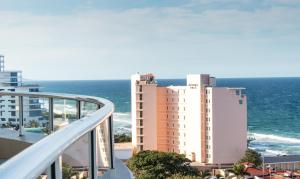 a balcony with a view of a building and the ocean at 801 Oyster Schelles - by Stay in Umhlanga in Durban