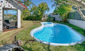 Villa Ti caz do miel avec piscine et bassin de détente à remous au Tampon pour 8 personnes في لو تامبون: مسبح في ساحة منزل