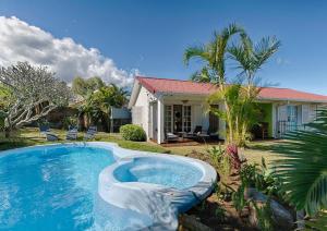 a swimming pool in front of a house at Villa Ti caz do miel avec piscine et bassin de détente à remous au Tampon pour 8 personnes in Le Tampon