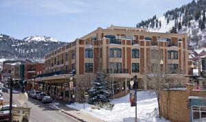a large building on a street with a snow covered mountain at The Caledonian by All Seasons Resort Lodging in Park City