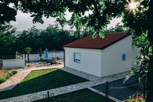 Ružići的住宿－HA-LU 1 - Holiday Relax Home，一座白色的小建筑,有红色的屋顶