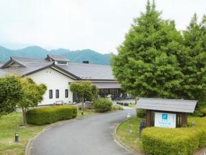 una casa con un árbol al lado de una carretera en Hotel Familio Minakami, en Minakami