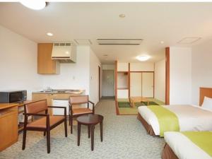 um quarto de hotel com uma cama e uma cozinha em Hotel Familio Minakami em Minakami