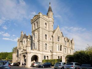 a large building with a clock on the front of it at Ardoe House Hotel & Spa in Aberdeen