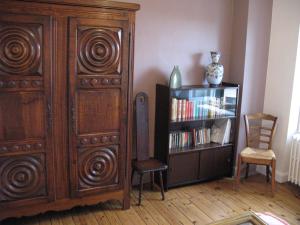 シャテル・ギヨンにあるLa Roche Pérégrineの大きな木製キャビネットと本棚が備わる客室です。