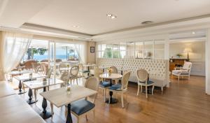 un ristorante con tavoli, sedie e finestre di Hotel BlauMar Llafranc a Llafranc