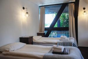 a hotel room with three beds and a window at Gospoda pod Czarnym Łabędziem in Rydzewo