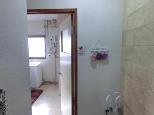 un bagno con porta aperta su un bagno con fiori sul muro di Almaz Place #205 a Sapporo Altre 47 foto