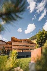 a building with trees in front of it at Aktiv & Familienhotel Adlernest in Senales