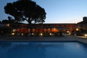 a swimming pool in front of a building at night at Hotel Van Gogh in Saint-Rémy-de-Provence