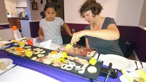a woman and a child preparing food on a table at Richards Travel Lodge in Jamestown