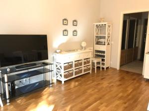 a living room with a large television and a wooden floor at Apartments in Vabaduse 72 in Narva-Jõesuu