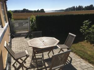a patio with a table and two chairs and a fence at Thurø Rev Guesthouse in Svendborg