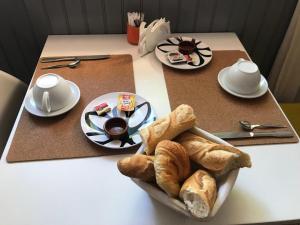 a table with a tray of bread and coffee on it at Hôtel Restaurant Le Commerce in Auriol