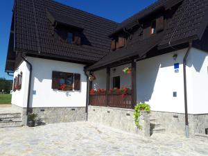 een wit huis met een zwart dak en ramen bij House Flora in Rastovača