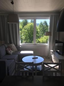 a living room with a couch and a table and a window at Paljakka Villas in Kotila