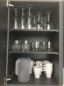 a shelf with cups and glass dishes in a kitchen at Paljakka Villas in Kotila