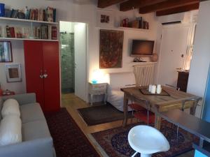 ein Wohnzimmer mit einem Tisch und ein Zimmer mit einem Bett in der Unterkunft Mini Contrà San Pietro in Vicenza