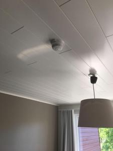 a white ceiling with a light and a window at Paljakka Villas in Kotila
