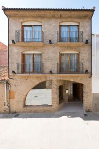 an external view of a brick building with balconies at Enoturismo Celler Piñol in Batea