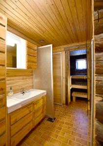 ein Badezimmer mit einem Waschbecken in einer Holzhütte in der Unterkunft Rantaruka 1A3 in Ruka