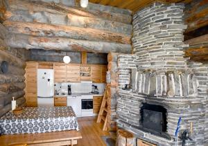 a kitchen with a stone fireplace in a log cabin at Rantaruka 1A3 in Ruka