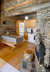 a kitchen in a log cabin with a bed and a stove at Rantaruka 1A3 in Ruka