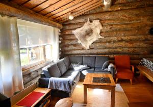 a living room with a couch and a log wall at Rantaruka 1A3 in Ruka