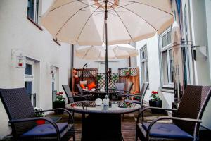 eine Terrasse mit einem Tisch, Stühlen und einem Sonnenschirm in der Unterkunft Hotel Engel in Hilders