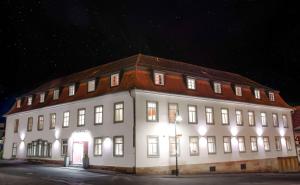 ein großes weißes Gebäude mit nachts eingeschaltetem Licht in der Unterkunft Hotel Engel in Hilders