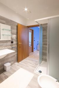 La salle de bains est pourvue d'une douche et d'un lavabo. dans l'établissement Ristorante Buasca, à Cuorgnè