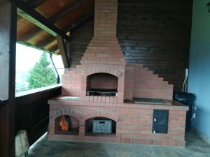 a brick oven in a room with a window at Casa Maria in Piatra Fantanele
