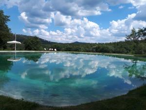 una piscina d'acqua con cielo nuvoloso di Agriturismo San Galgano a Chiusdino