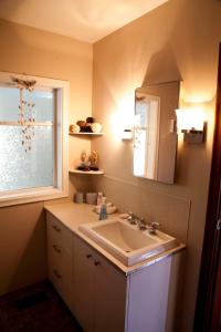 La salle de bains est pourvue d'un lavabo, d'un miroir et d'une fenêtre. dans l'établissement Marge's Manor, à Sooke