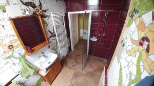 y baño con lavabo y ducha con azulejos morados. en Ziegeleihof inmitten von Wiesen und Wäldern, en Degenershausen