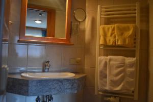 een badkamer met een wastafel, een spiegel en handdoeken bij Fesengut in Annaberg im Lammertal
