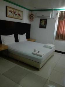 a bedroom with a bed and a table in it at Asia Novo Boutique Hotel - Kalibo in Kalibo