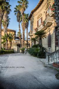 une rue en face d'un bâtiment avec des palmiers dans l'établissement Bnb Villa Lendi, à Frattamaggiore