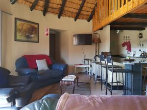 a living room with a couch and a bar at Blackbrook Farm Underberg in Underberg