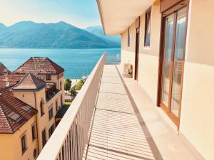 a balcony with a view of the water and buildings at Attico Palazzo di Vetro in Luino