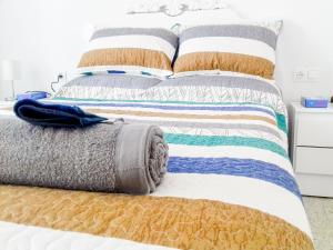 ein Bett mit bunten Decken und Kissen darauf in der Unterkunft Gran Notch in Alicante