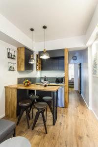 a kitchen with a wooden table and stools at Lazaristes Compact Living in Thessaloniki