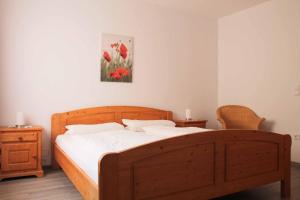1 dormitorio con cama de madera con sábanas blancas en Feriendorf Nehmeier, en Haundorf