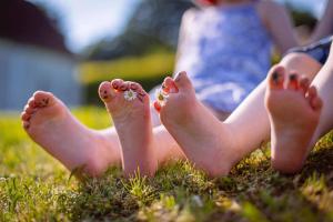 un par de pies desnudos sentados en la hierba en Feriendorf Nehmeier, en Haundorf
