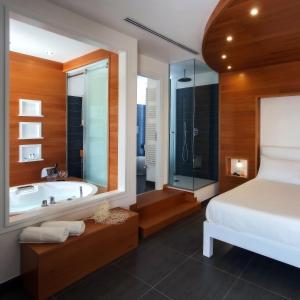 a bathroom with a large tub and a large mirror at La Sciabica in Agropoli